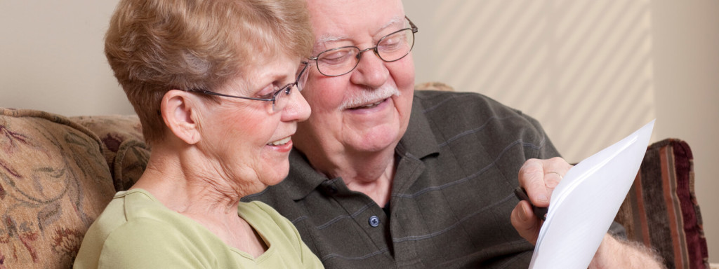 Image of a smiling senior couple reading a will